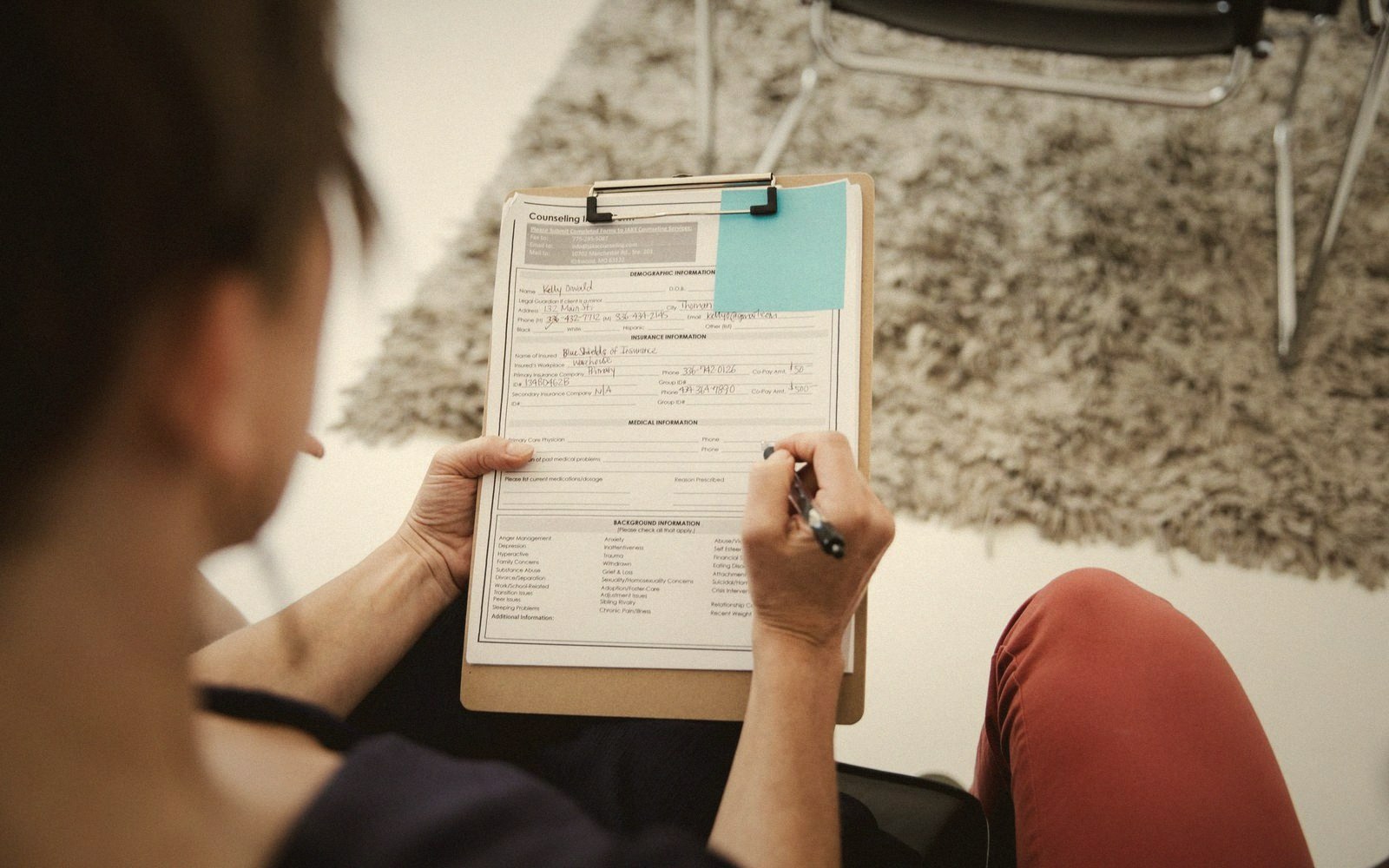 Hands filling in an intake card on a clipboard